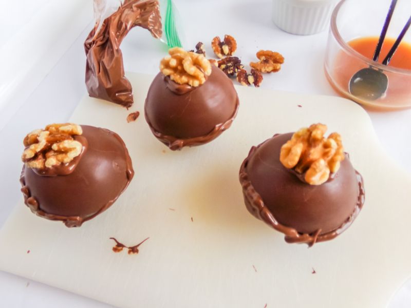 hot cocoa bombs topped with caramel and a walnut
