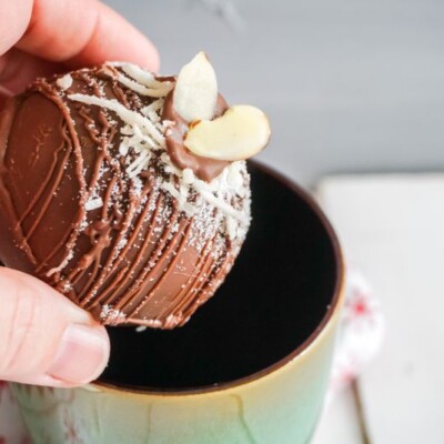 putting almond joy hot cocoa bombs in mug