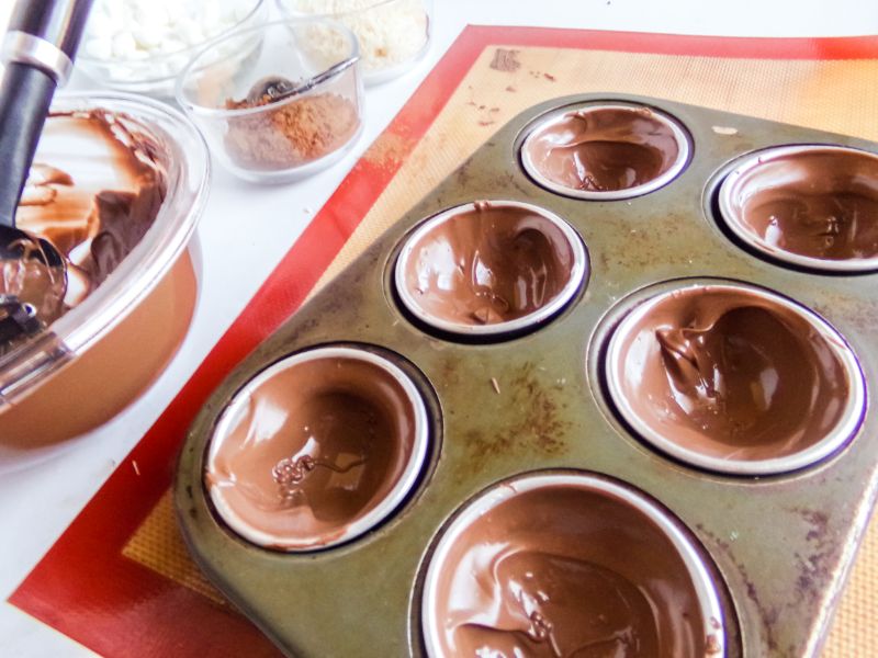 adding melted chocolate to molds