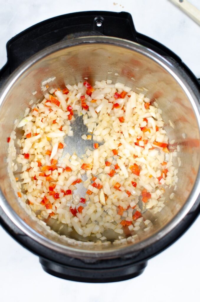 onions and bell pepper cooking in an instant pot