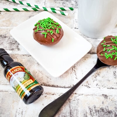 Irish Creme Liqueur Cocoa Bombs on plate with Irish creme bottle