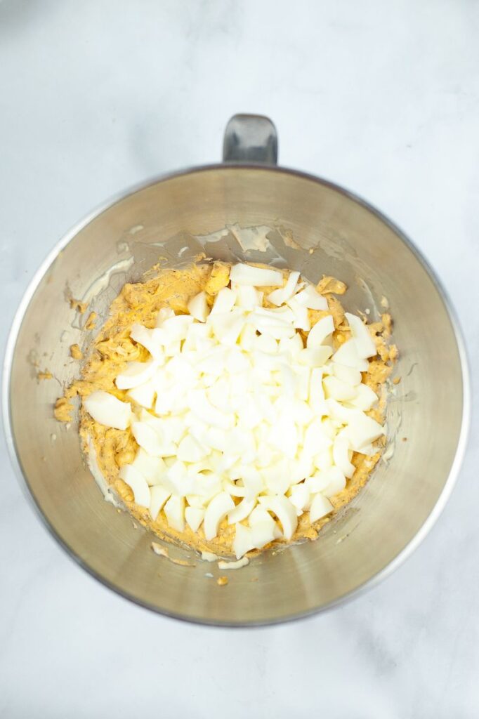ingredients for an egg salad sandwich in a metal mixing bowl 