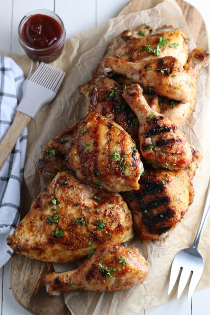 Grilled BBQ chicken on wooden platter 