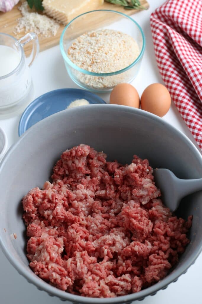 adding ground meat to bowl