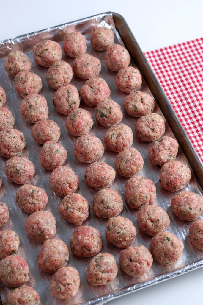 raw meatballs on a baking sheet 