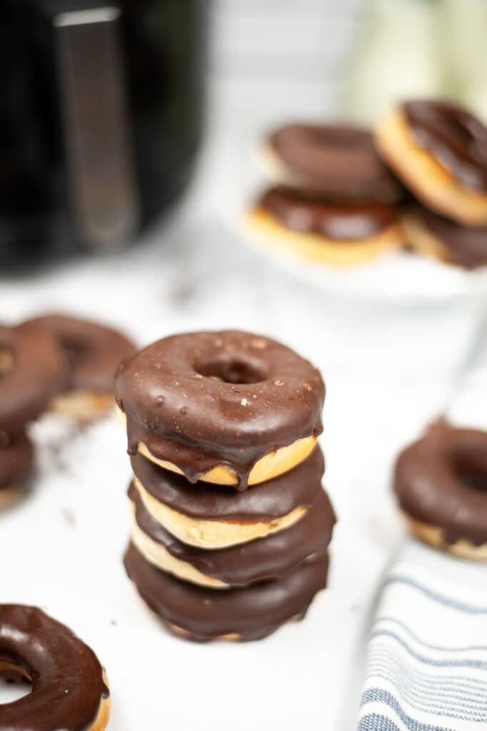 glazed chocolate donut stacked on other donuts 