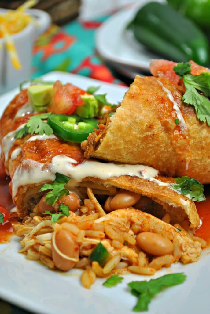 close up of a square white plate with chicken chimichangas on it 