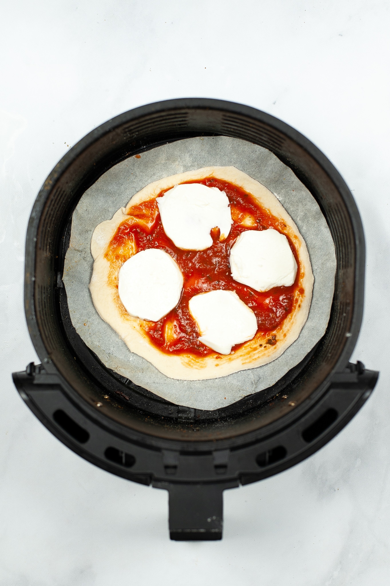 adding sliced mozzarella to the top of the pizza 