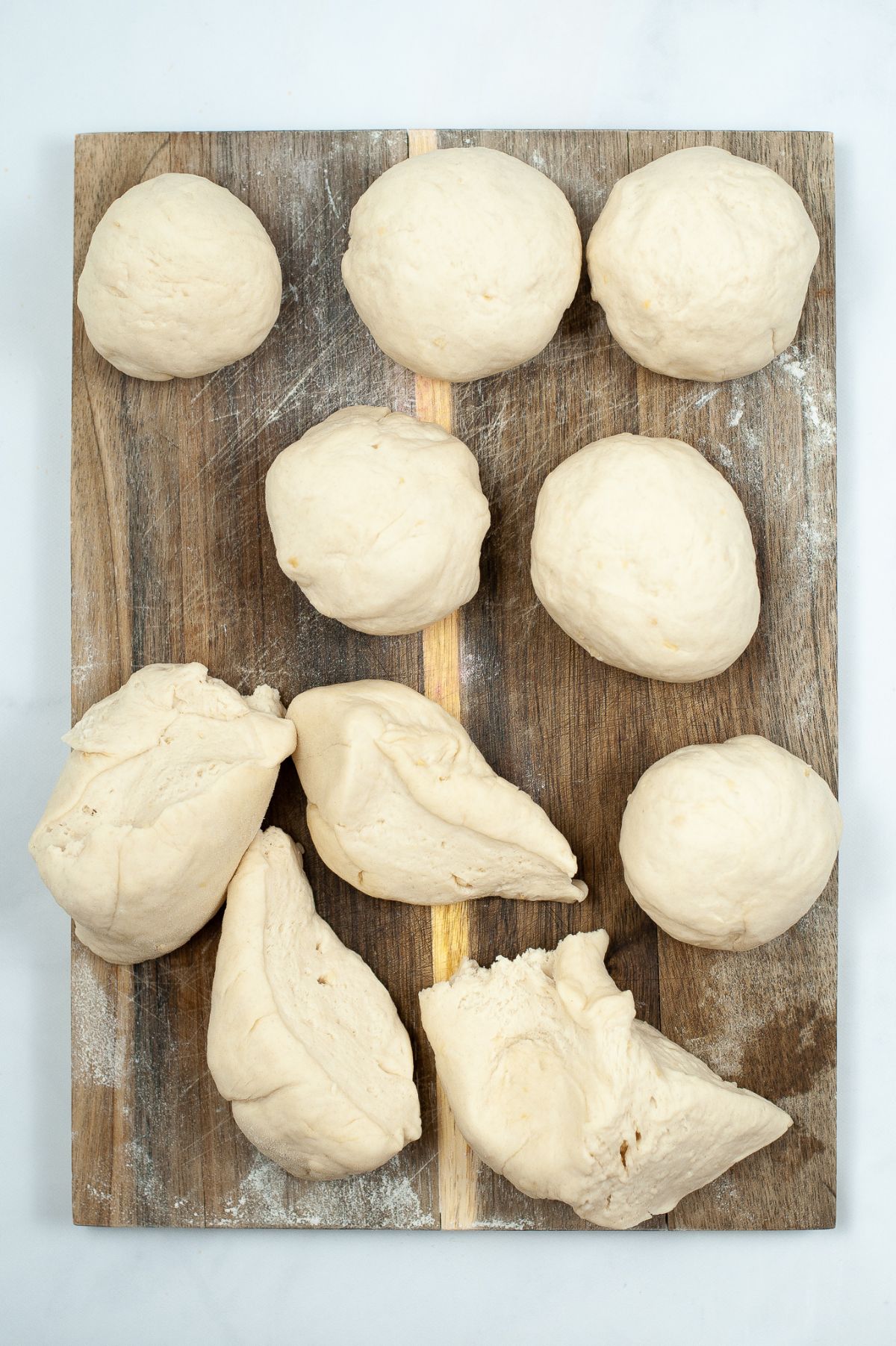 10 parts of dough shaped into a ball on floured flat surface.