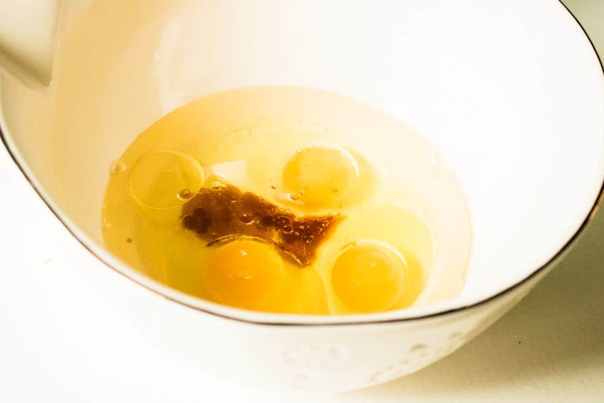A bowl of the combined wet ingredients: eggs, vegetable oil, and vanilla extract
