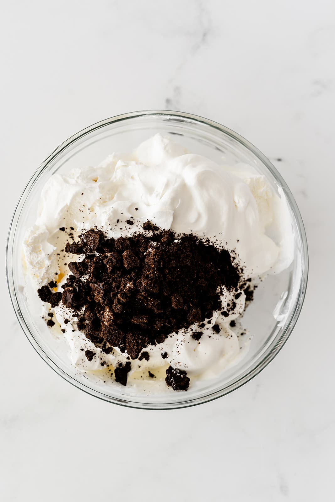 crushed Oreos and cool whip in a glass bowl