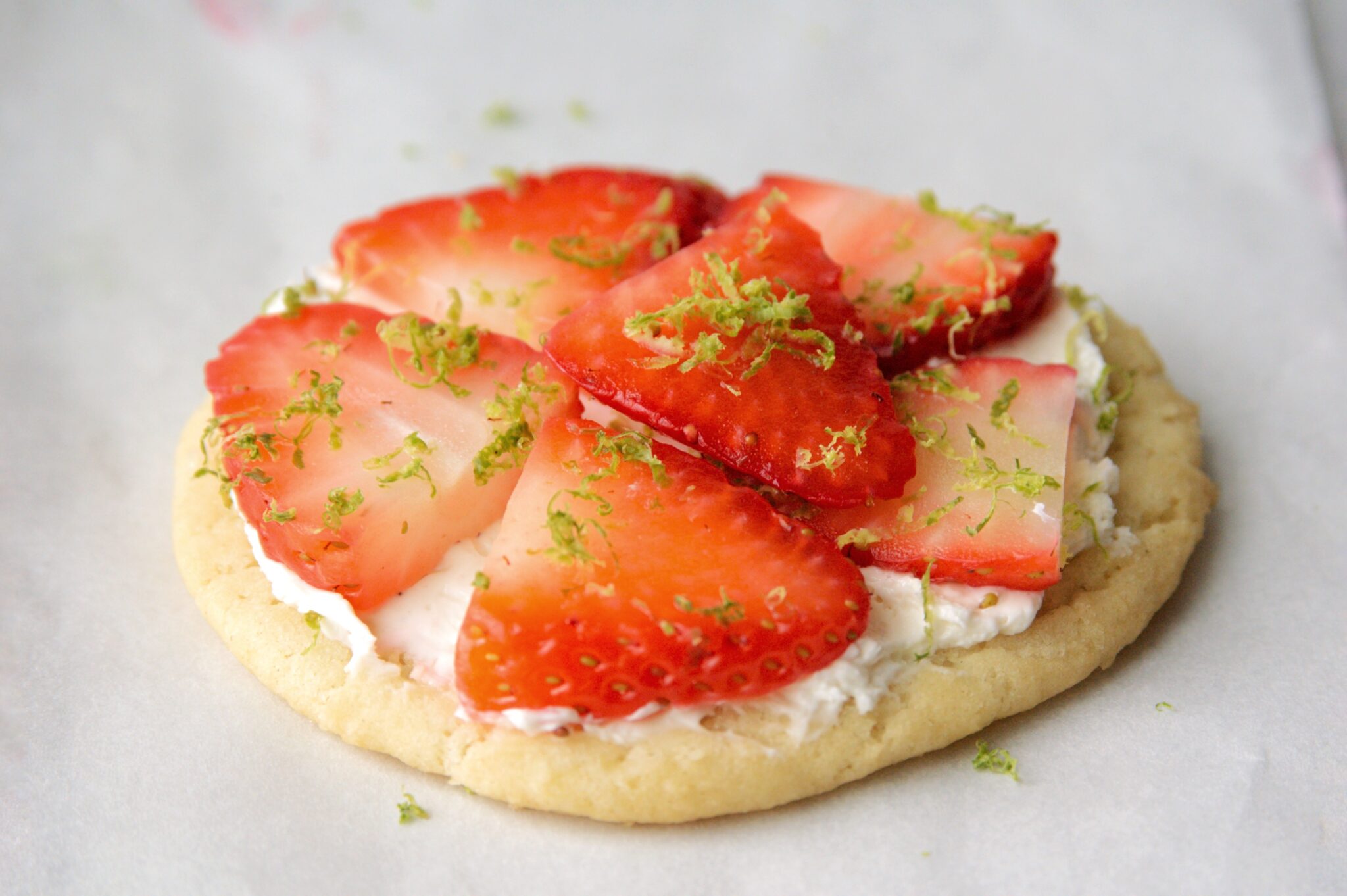 close up of strawberry slices on sugar cookie 