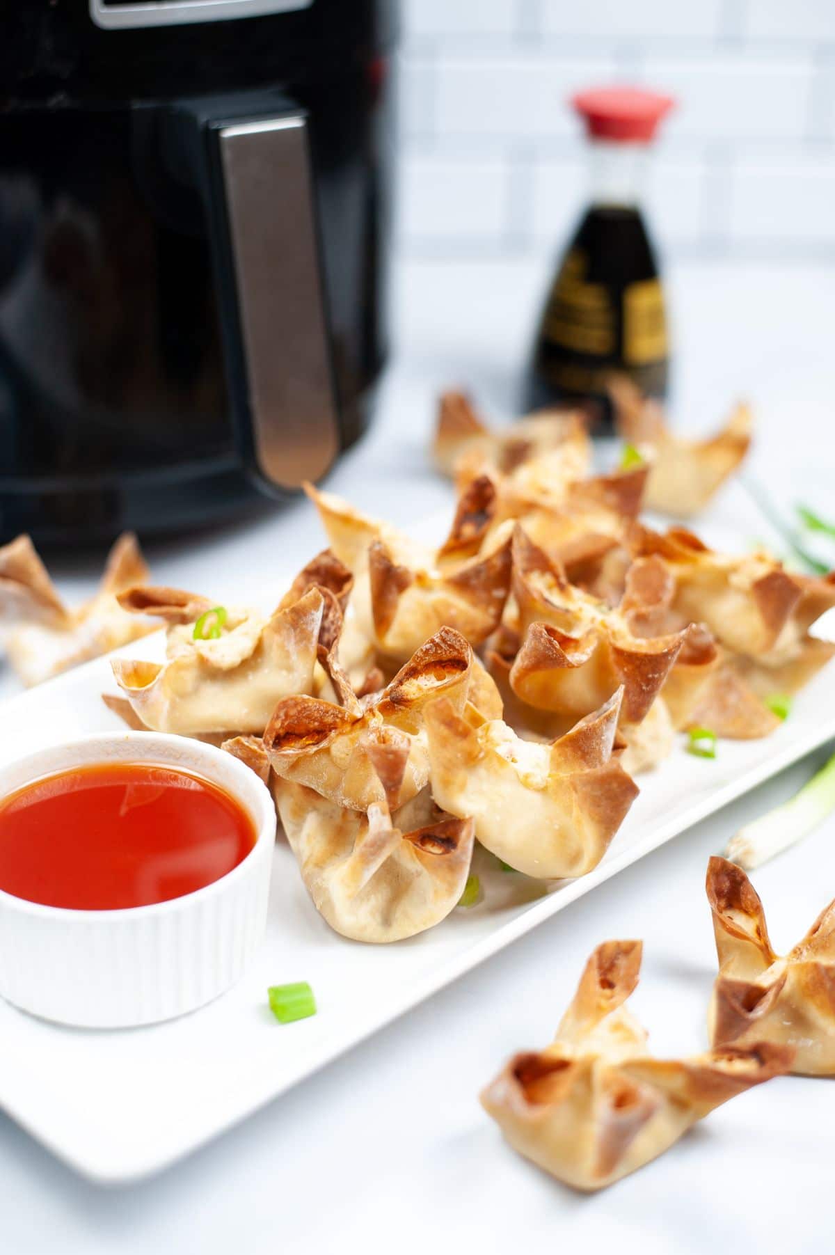 crab rangoon on white plate with dipping sauce