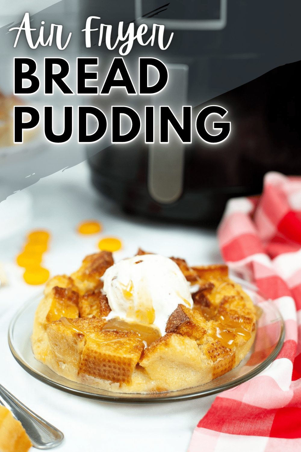 A vertical image of Air Fryer Bread Pudding on a glass serving plate with an air fryer in the background and text at the upper left corner which says "Air Fryer Bread Pudding"