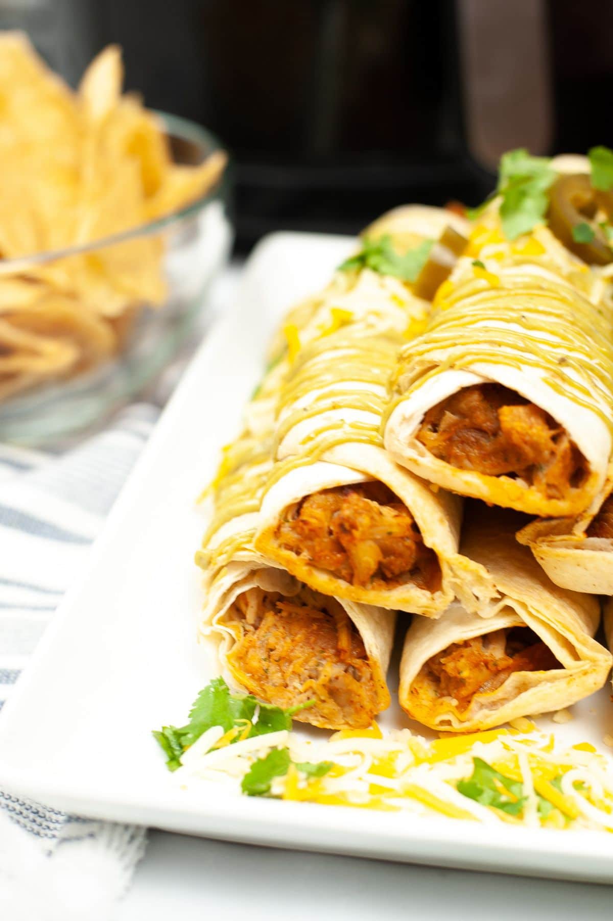 A side view shot of Air Fryer Chicken Taquitos highlighting the chicken inside the wrap.