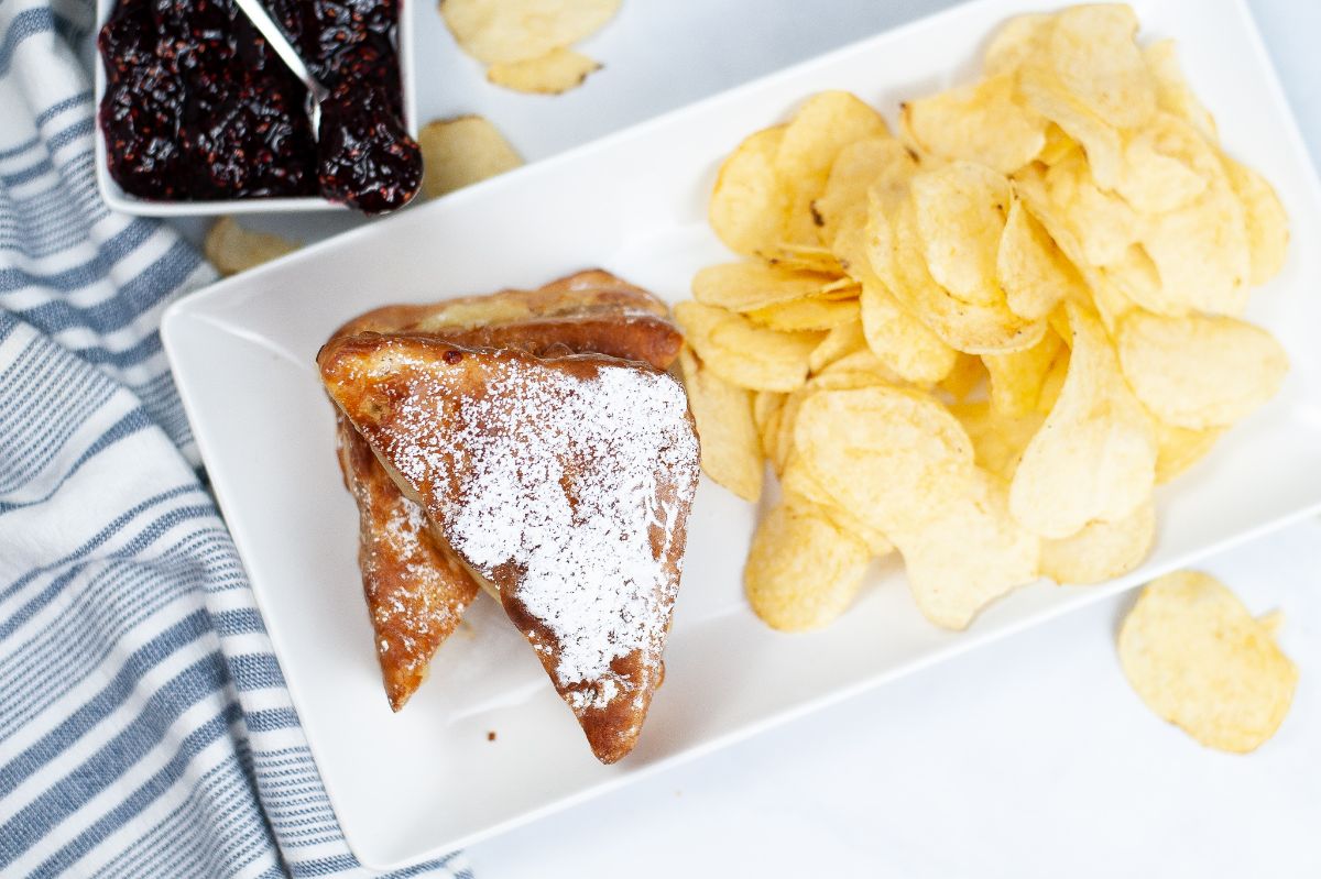 An overhead horizontal image of of Air Fryer Monte Cristo on white platter with chips on the side.