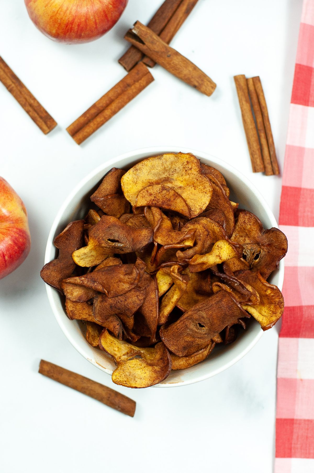 A vertical image of Air Fryer Cinnamon Apple Chips in a white bowl.
