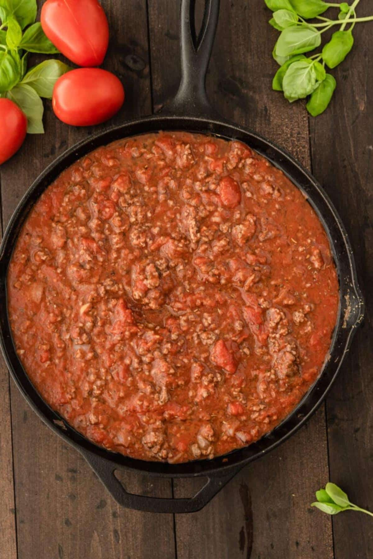 Ground beef and tomatoes in cast iron skillet.