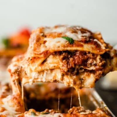 Lasagna being taken out of a baking dish in a Classic Lasagna Recipe with Ground Beef.