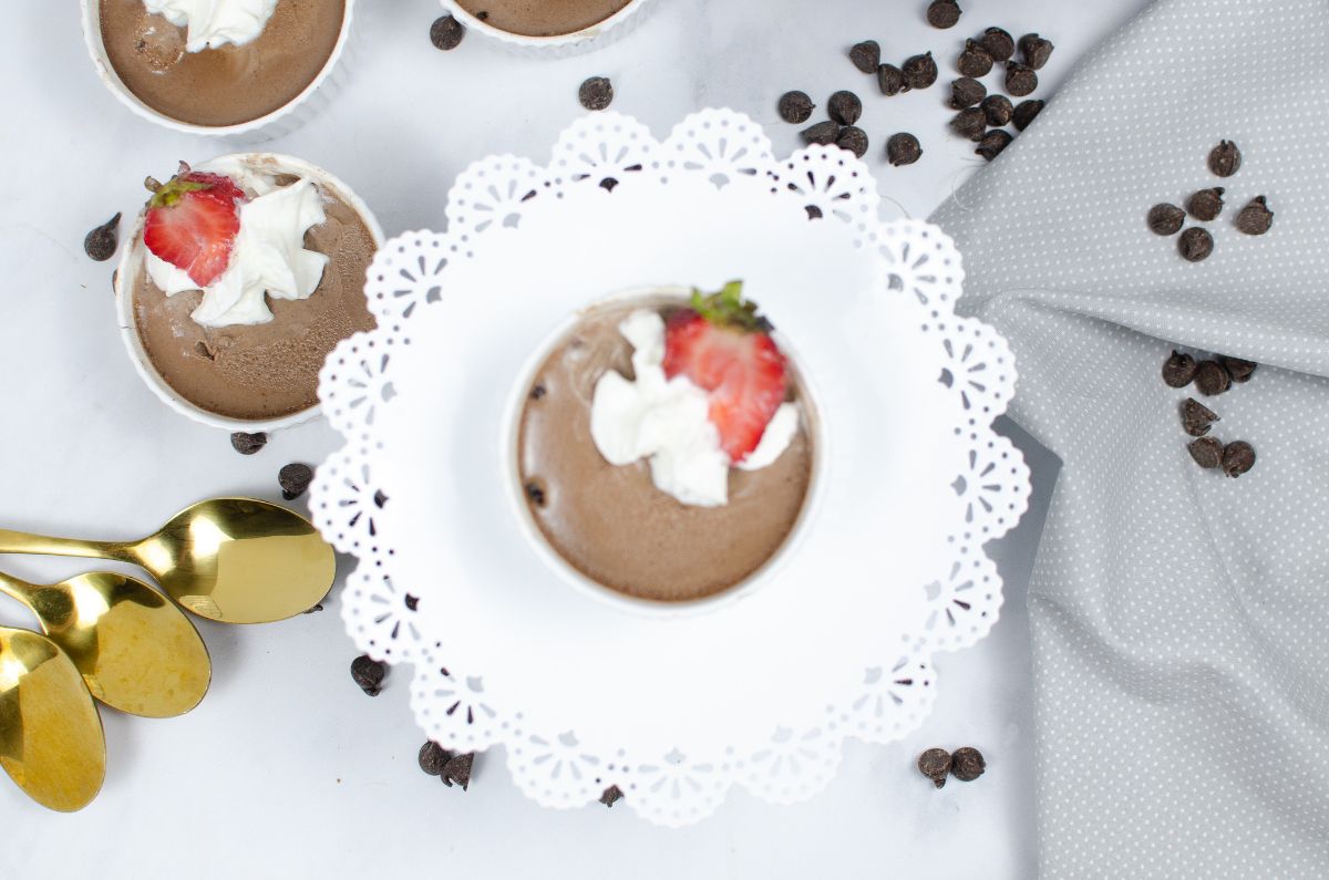 An overhead horizontal shot of  Instant Pot Chocolate Mousse in a white ramekin placed at the center of a circular cake stand..