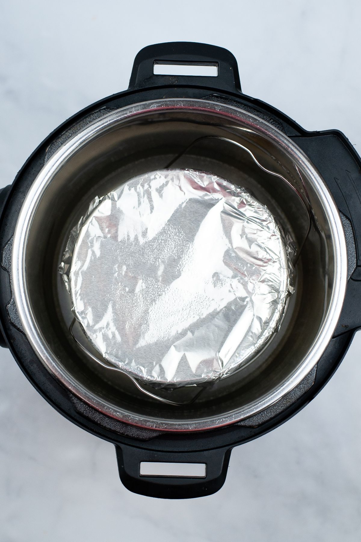 A baking pan covered with aluminum foil, placed inside the instant pot.