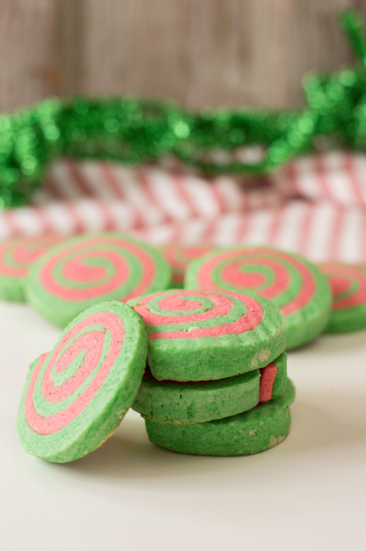 A vertical image of Christmas Pinwheel Cookies that are stacked.