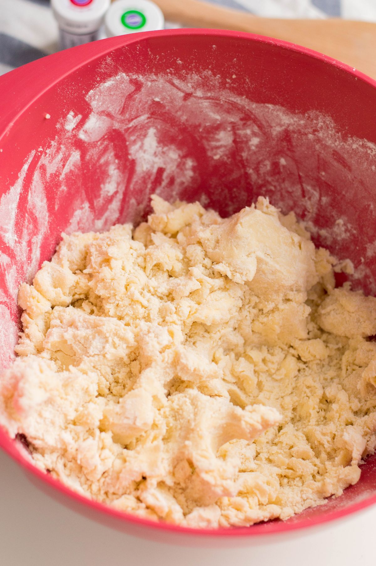 Creamed butter and sugar in a red mixing bowl with eggs, vanilla, and some ingredients added to it.