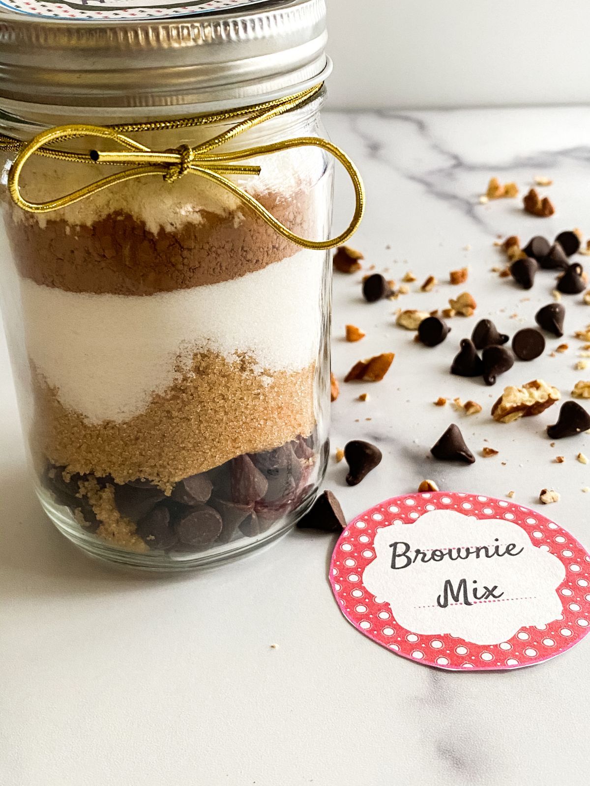 An image of the Brownie Mix in a Jar showcasing its layers and a circular tag beside it saying "Brownie Mix"