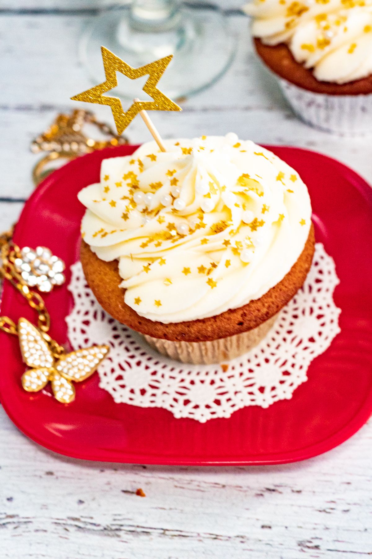 A Champagne Cupcake on a red decorated plate.