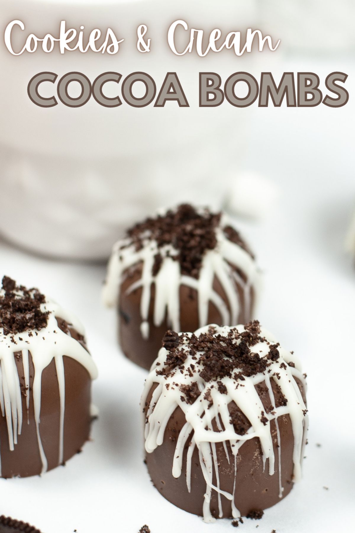 A vertical image of Cookies and Cream Hot Cocoa Bombs with a text at the top of the image saying "Cookies and Cream Cocoa Bombs"