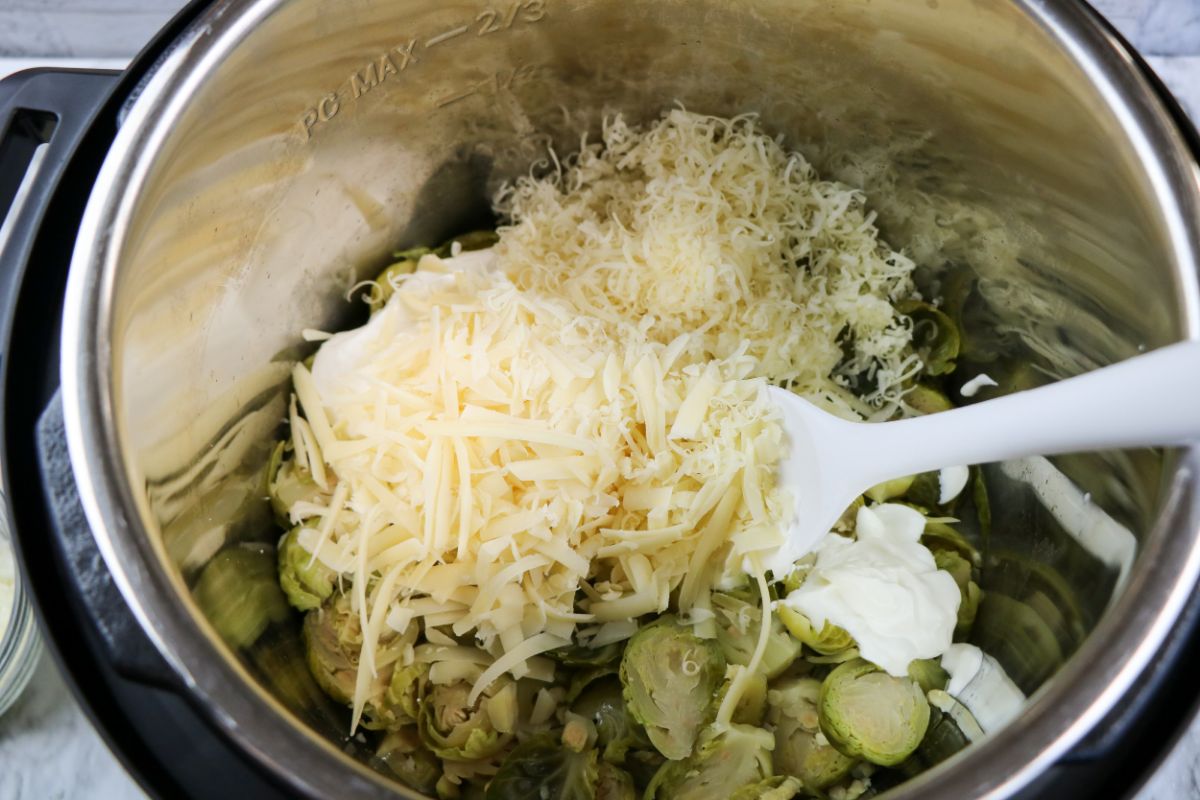 Remaining ingredients being added on top of the cooked brussels in an Instant pot.