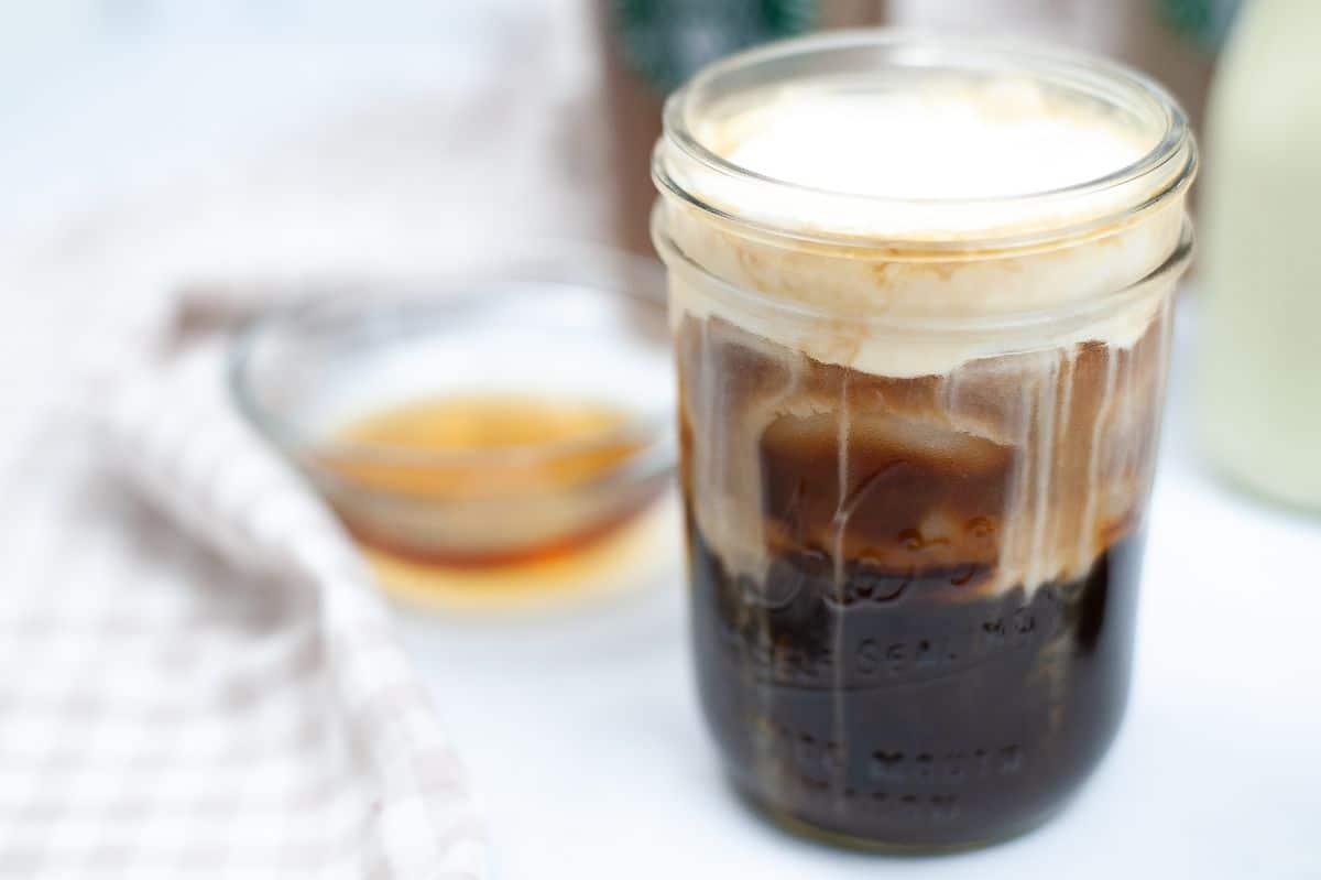 Starbucks Copycat Vanilla Sweet Cream mixed into a glass of cold coffee.
