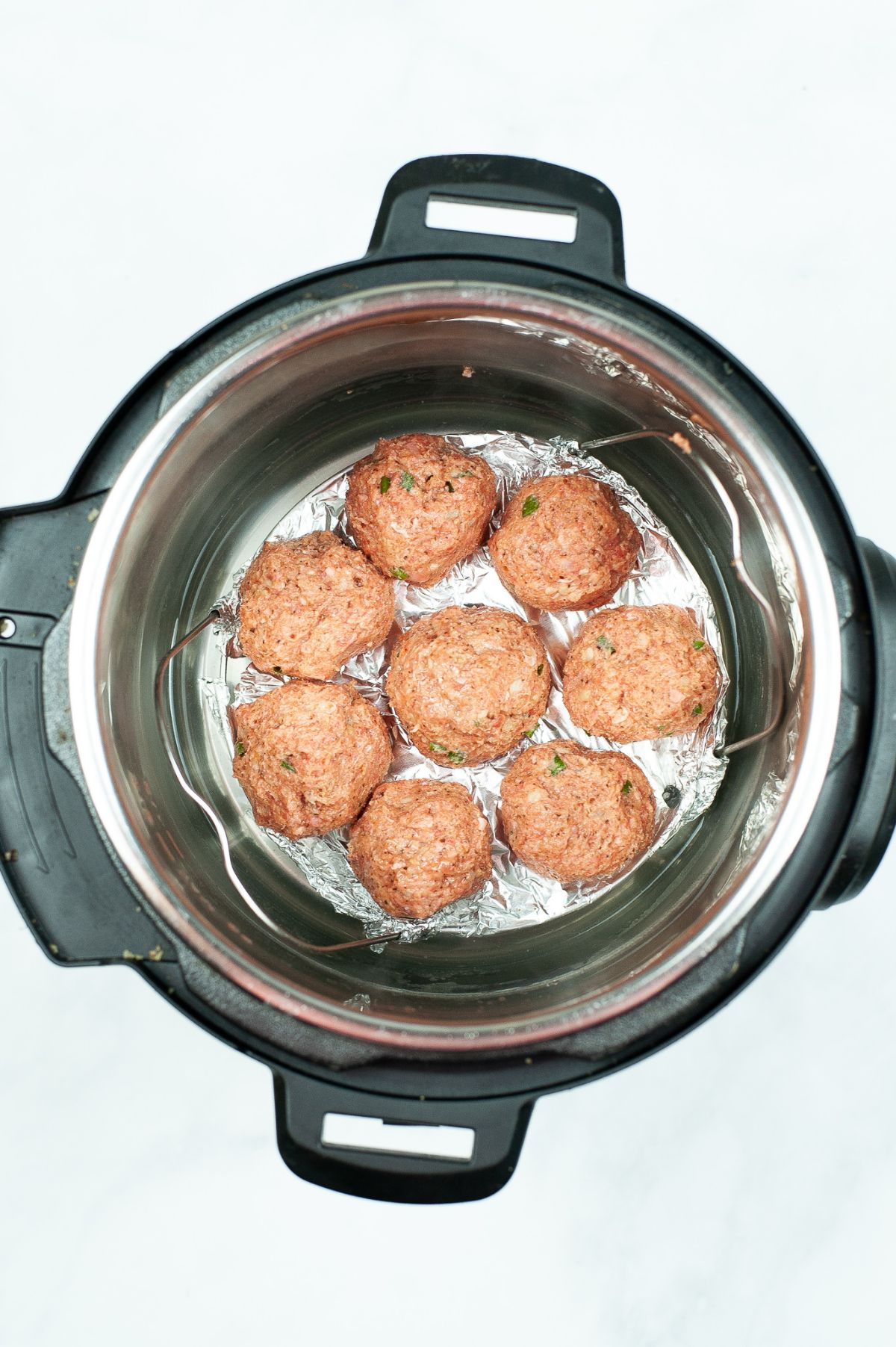 Shaped meatballs placed in an instant pot ready for cooking.