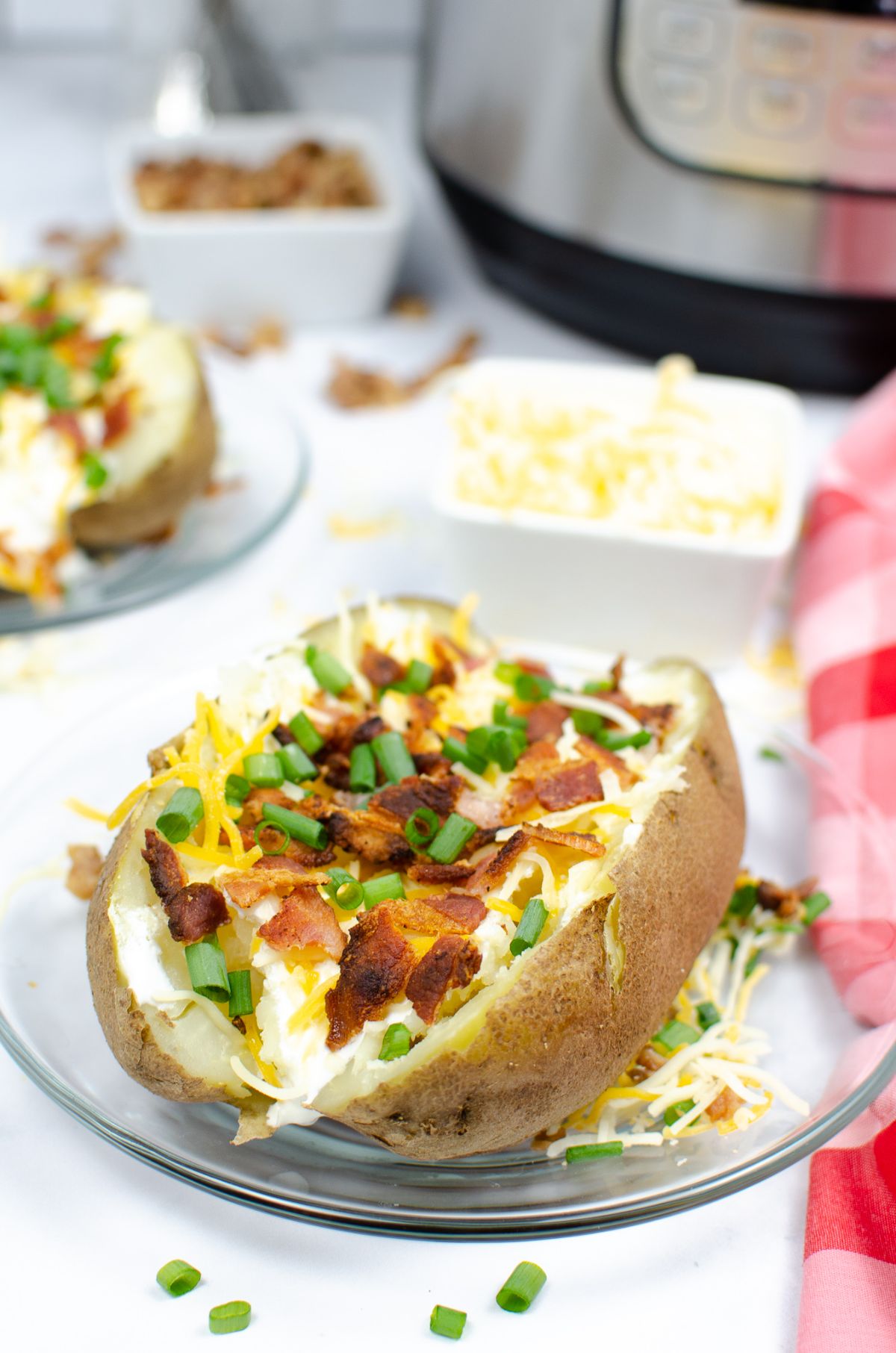Instant Pot Baked Potato on a clear serving plate.
