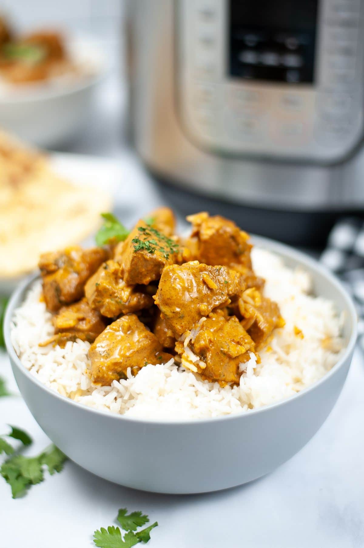 Instant Pot Butter Chicken on top of a bowl of rice.