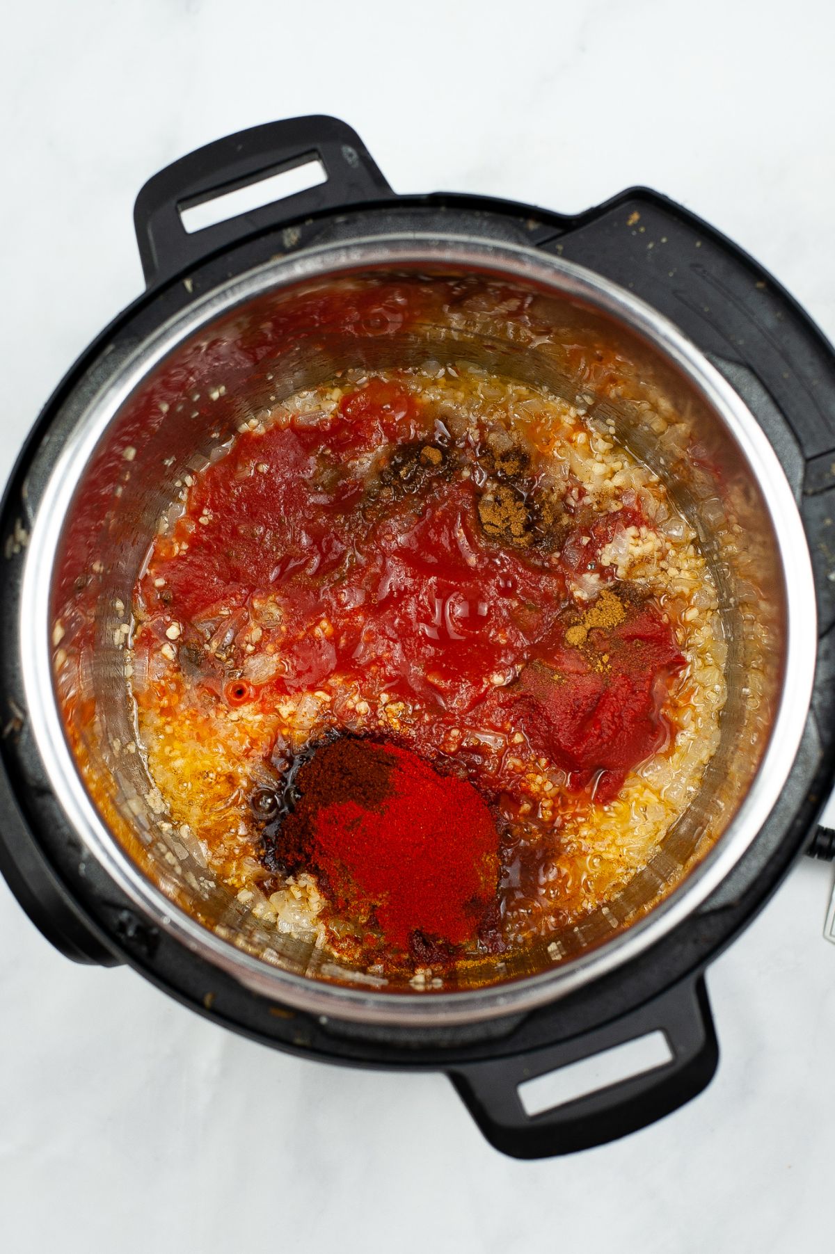 Browned chicken in the instant pot with added spices, tomato sauce, tomato paste