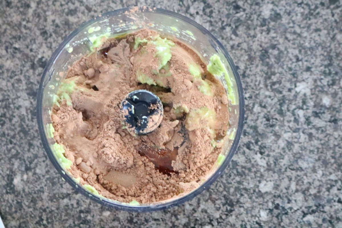 Cacao powder added into the avocados in the food processor.
