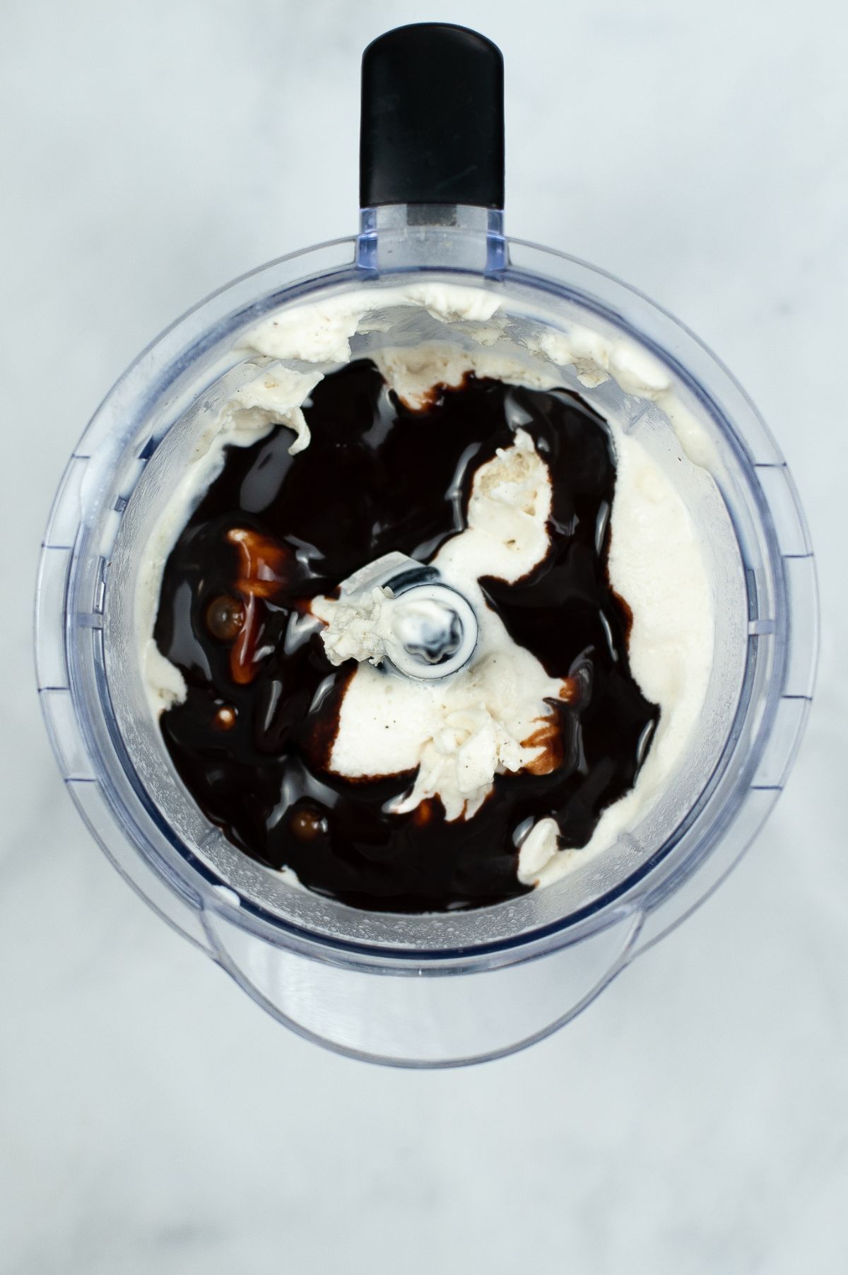 Ice cream and chocolate syrup added into the mixture in the blender.