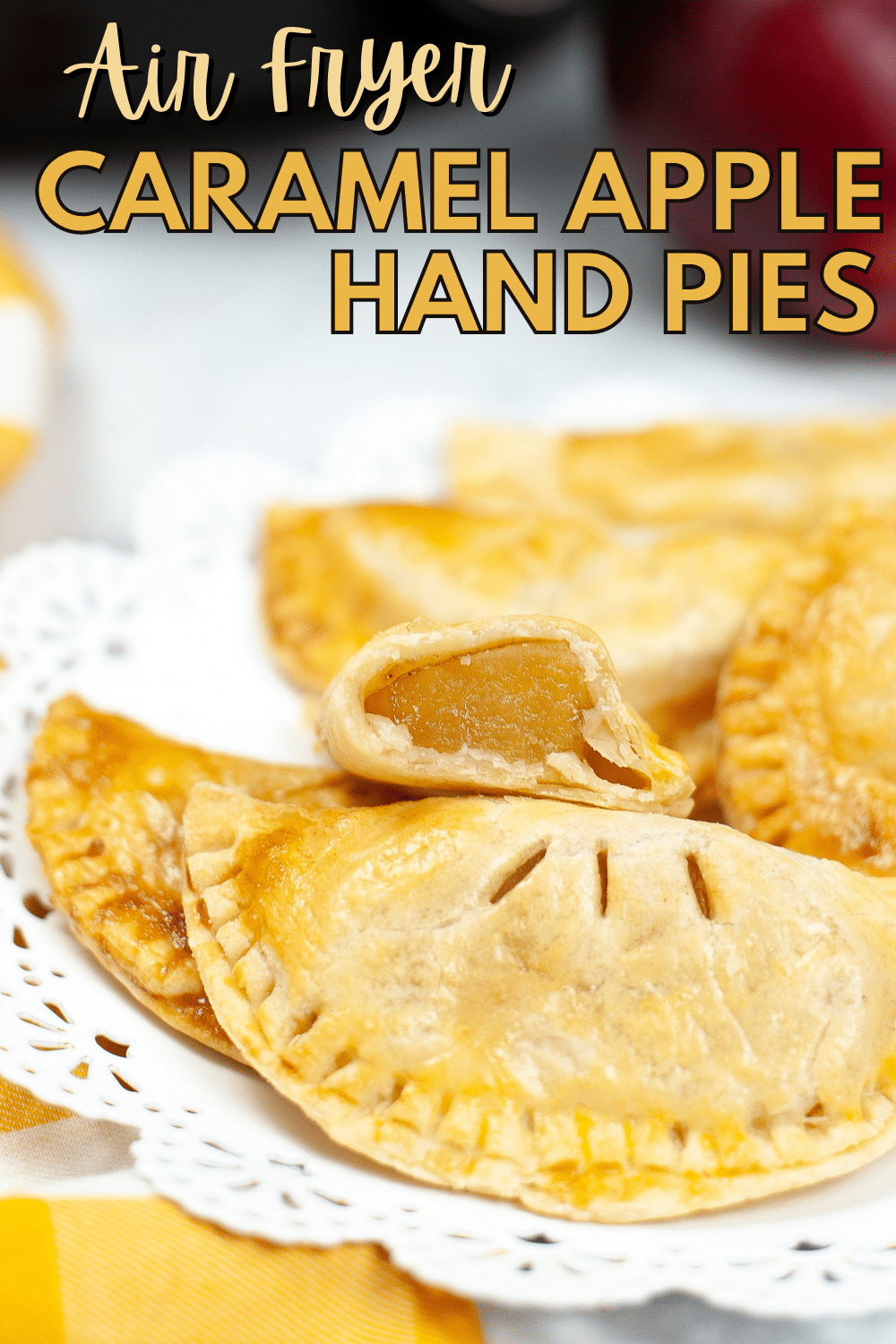 a closeup of Caramel Apple Hand Pies with one sliced in half so you can see the apple inside with title text reading Air Fryer Caramel Apple Hand Pies