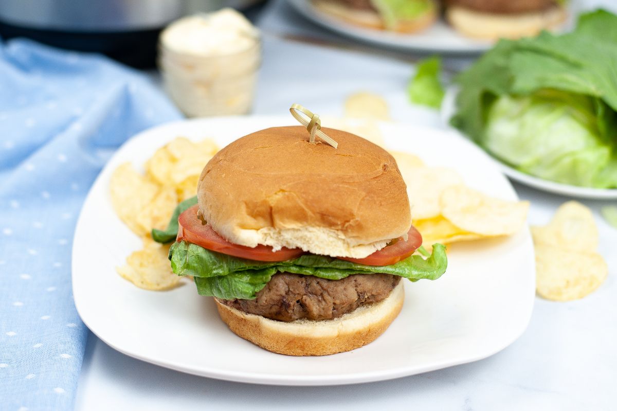 Instant Pot Turkey Burgers on a white square plate with potato chips.
