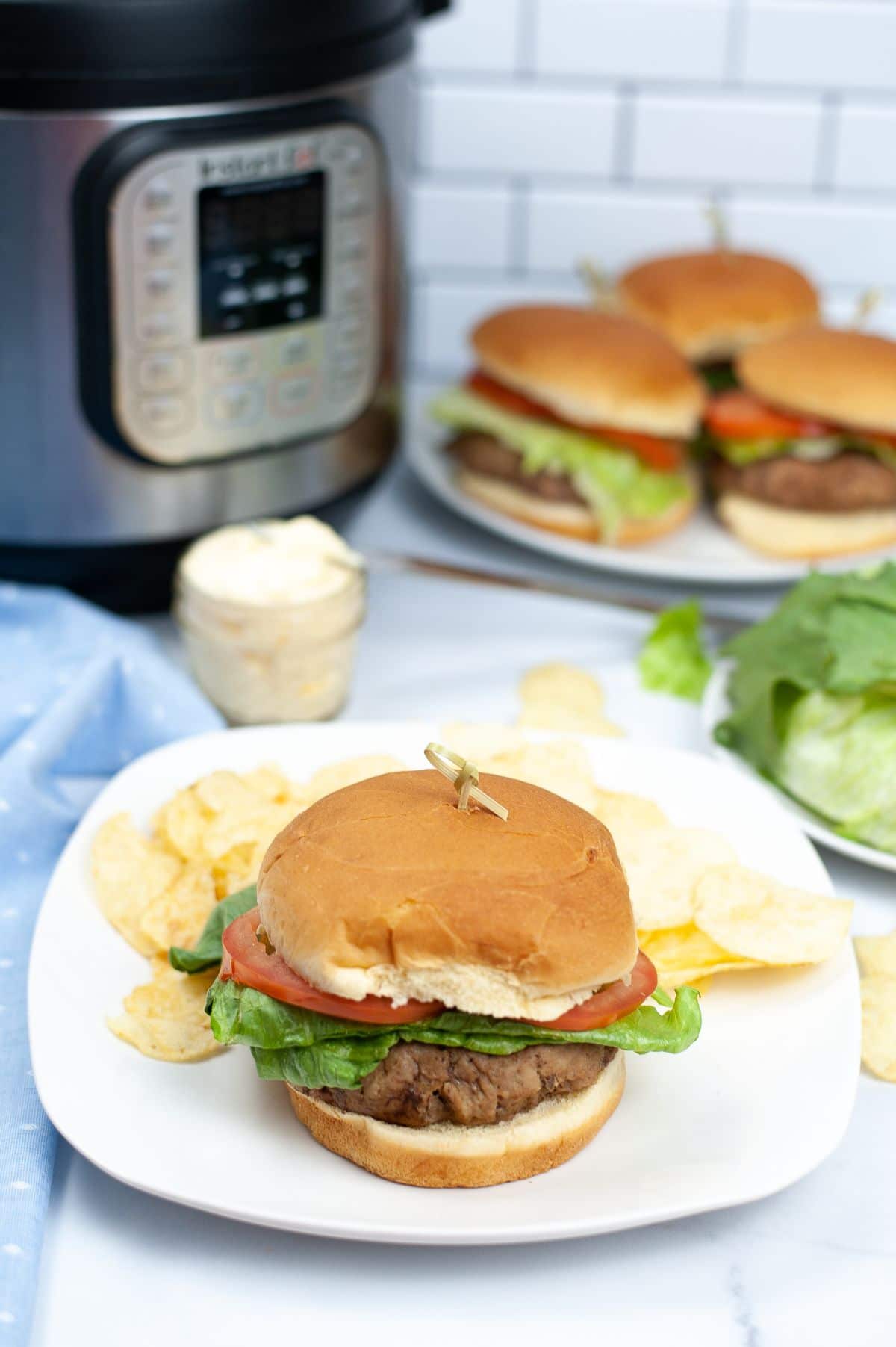 Instant Pot Turkey Burgers on a white square plate with potato chips.