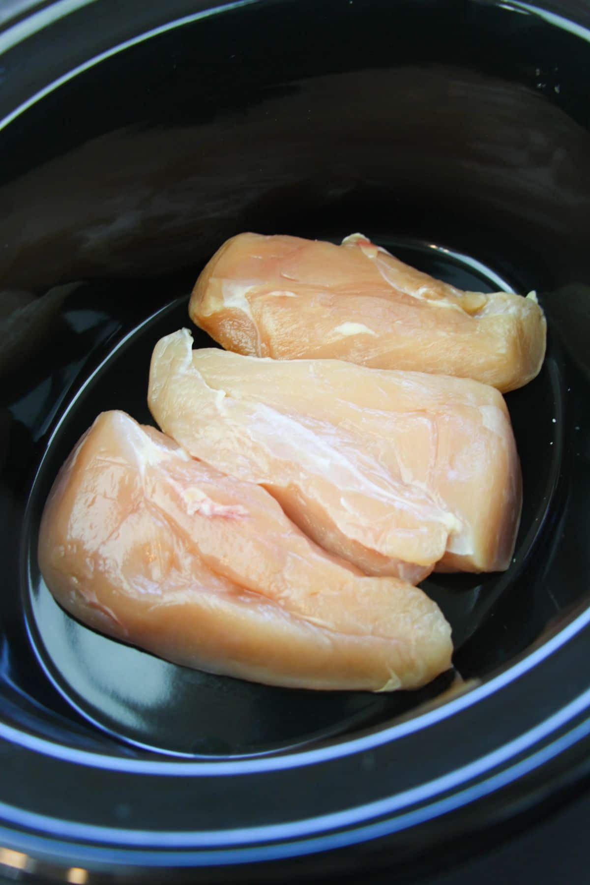 3 pieces of Chicken breast in a crockpot.