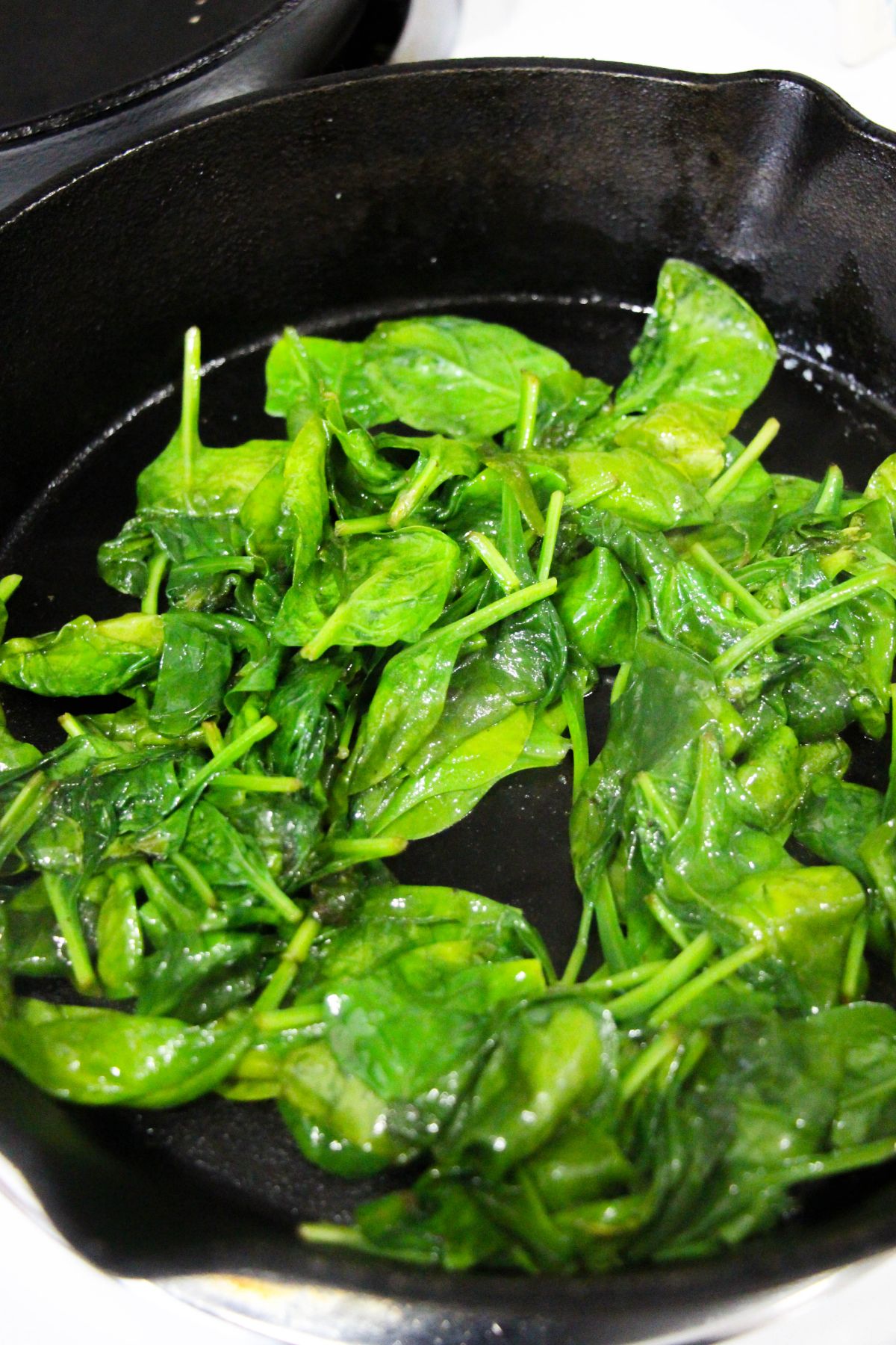 butter and spinach being cooked in a pan