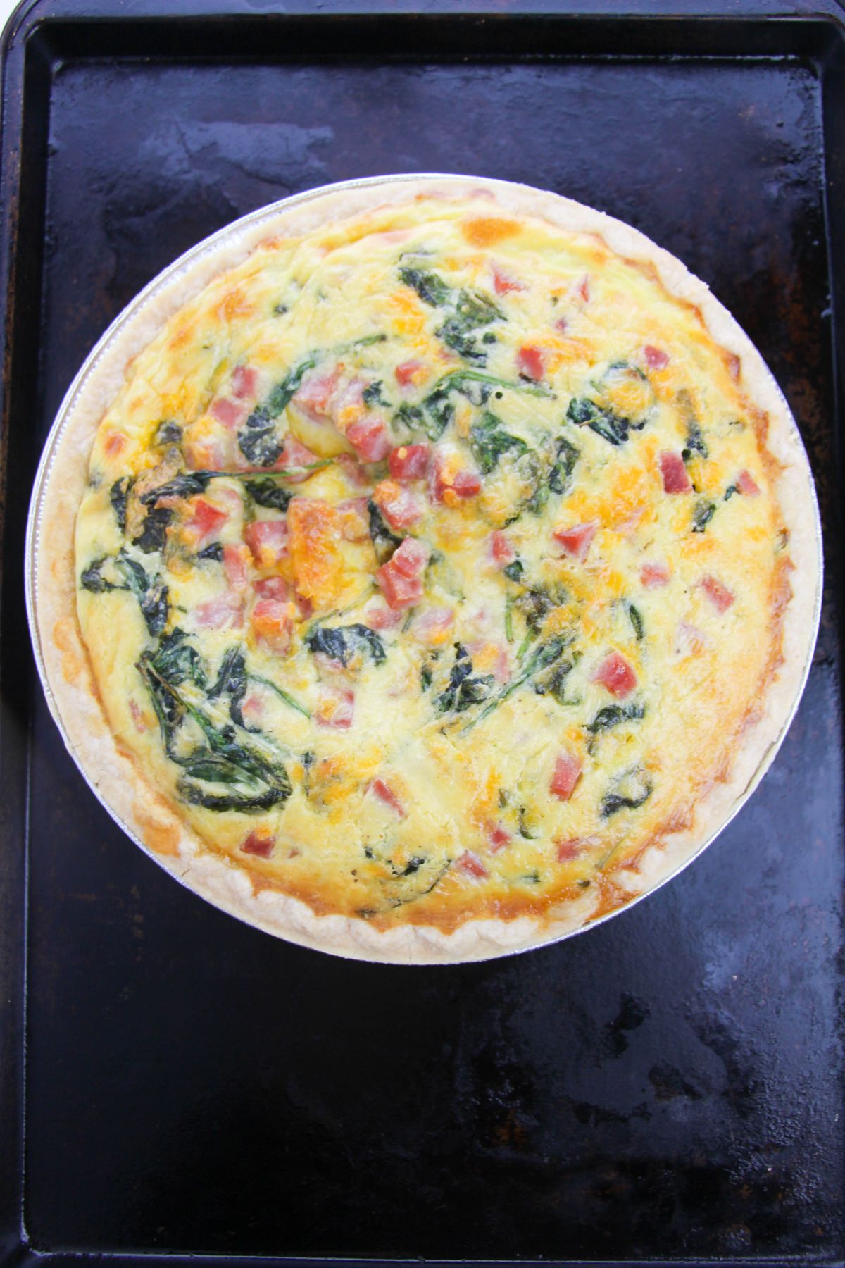 Baked Ham Spinach Cheese Quiche on a baking sheet