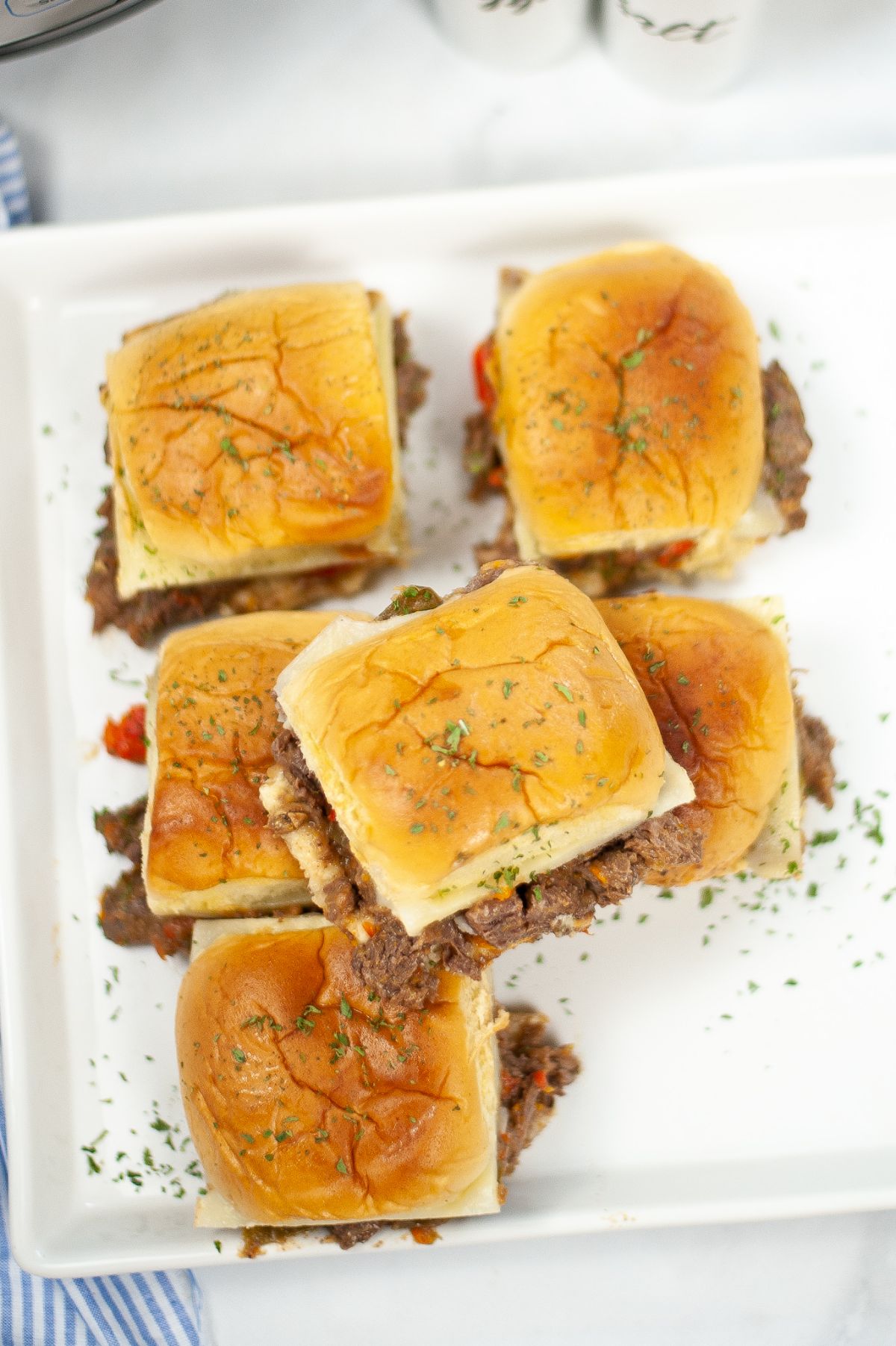 Instant Pot Philly Cheesesteak Sliders on a white plate top with chopped parsley