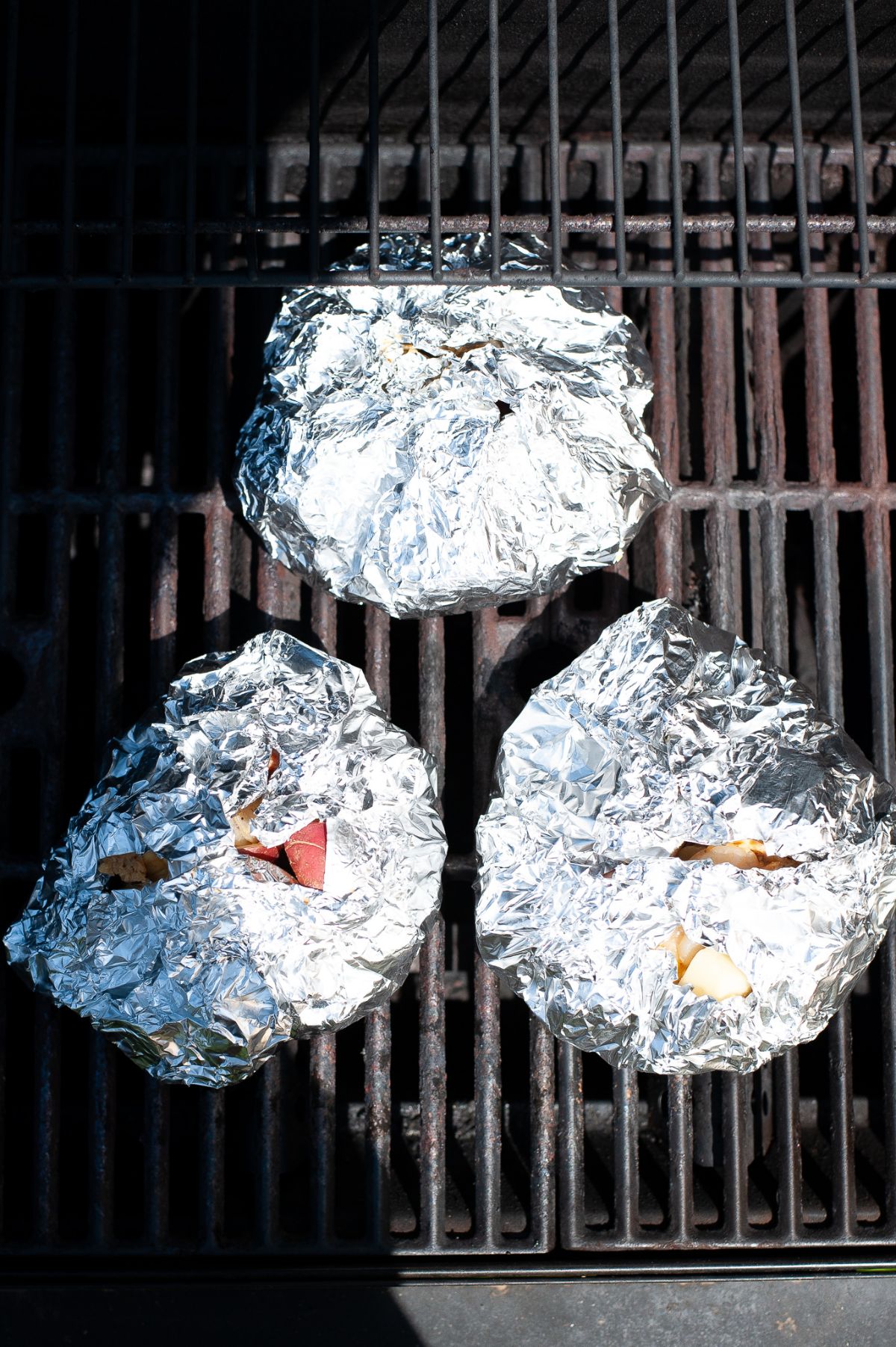 three closed Low Country Boil Foil Packets on the grill
