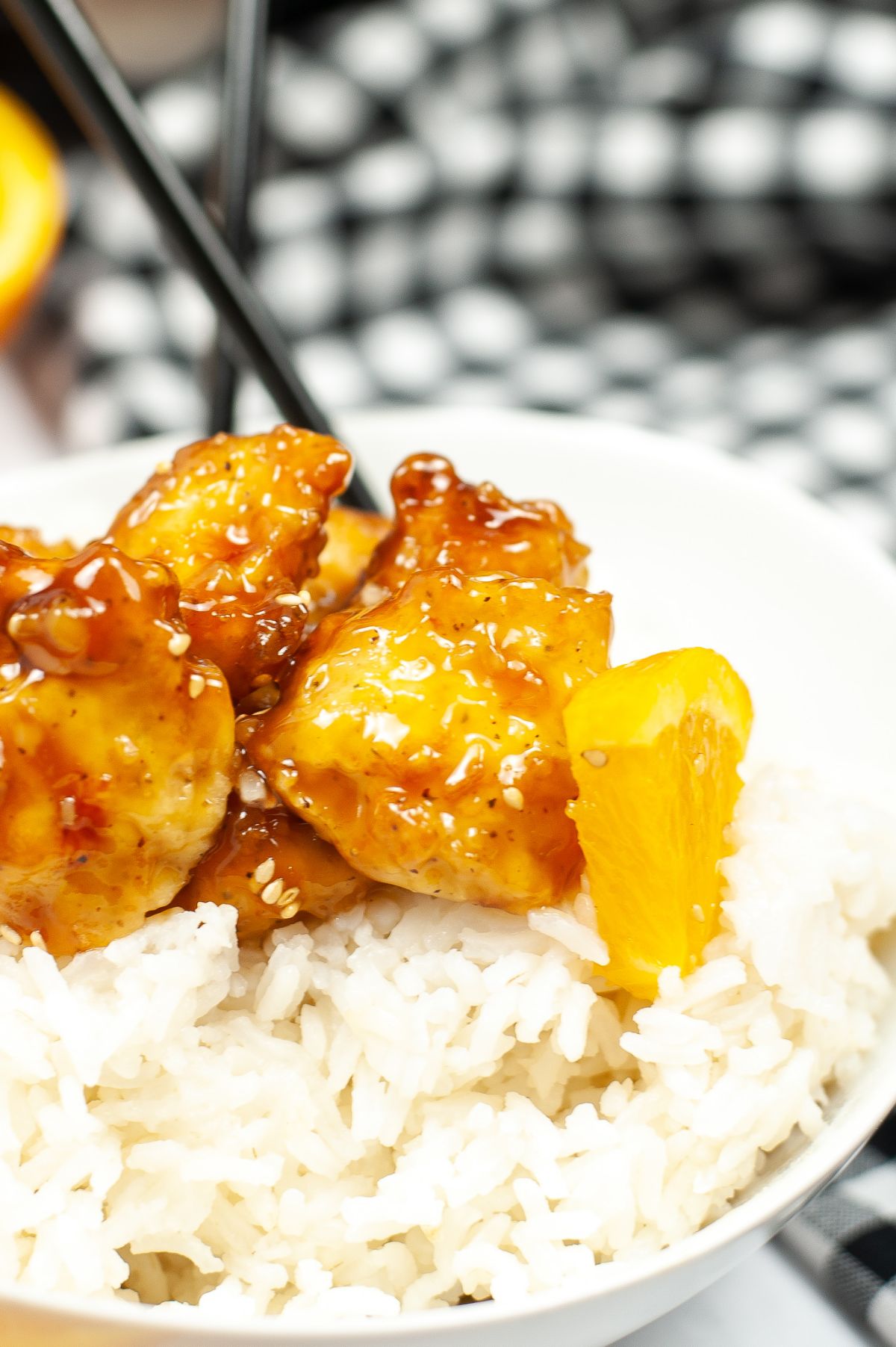 a closeup of Air Fryer Copycat Panda Express Orange Chicken in a white bowl with rice  