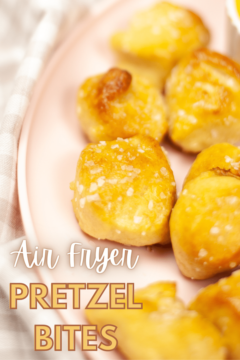 a closeup of pretzel bites on a pink plate with title text reading Air Fryer Pretzel Bites