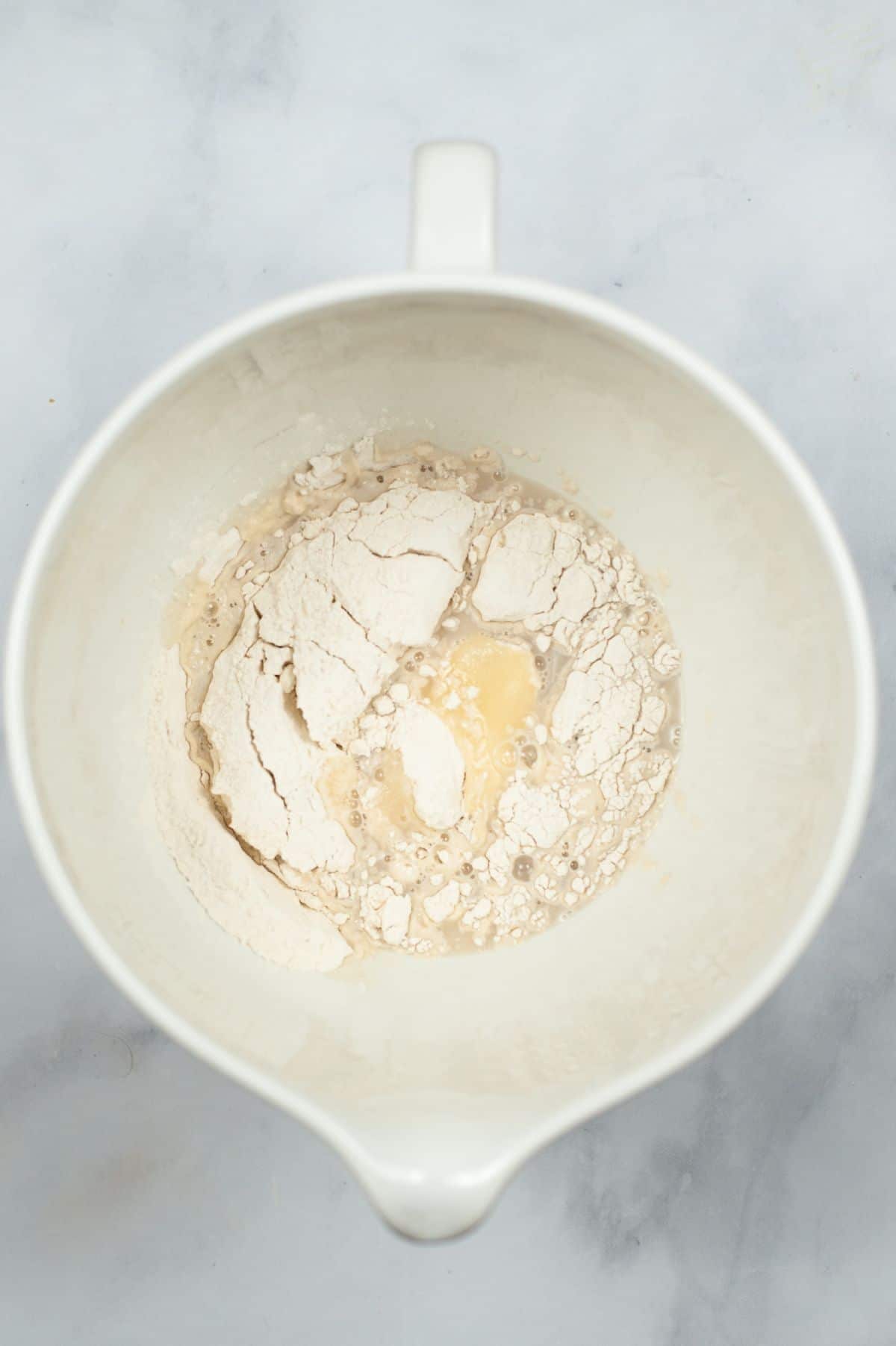 flour, sugar and yeast mixture in a white bowl