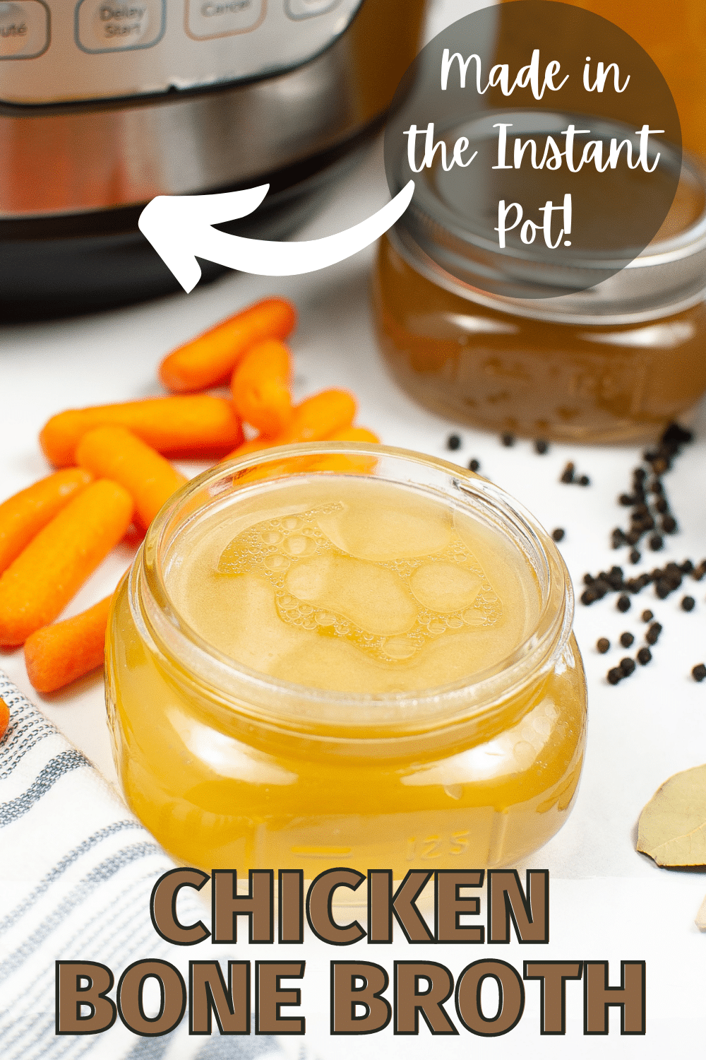overhead view of Instant Pot Chicken Bone Broth in a jar next to carrots, peppercorns and bay leaves with an instant pot in the background and title text reading Chicken Bone Broth Made in the Instant Pot